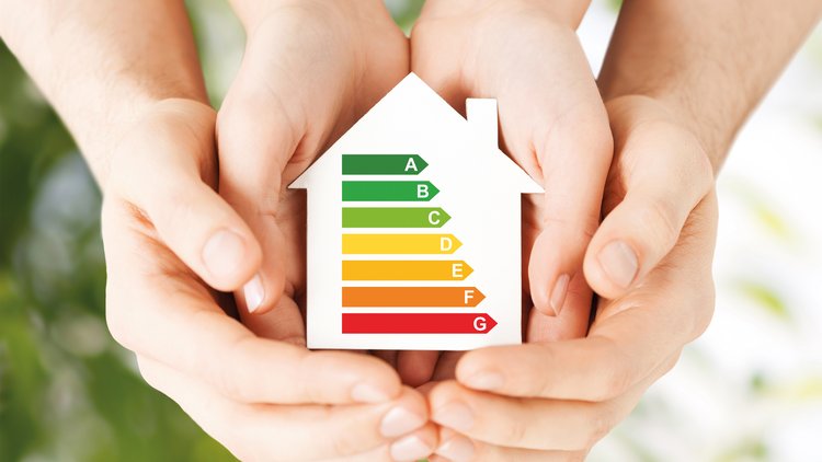This graphic shows two pairs of hand cradling a model of a house with colour symbols showing various energy ratings.